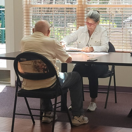 Miembro del personal de Act Now Foundation realizando una evaluación de memoria gratuita a una persona mayor.