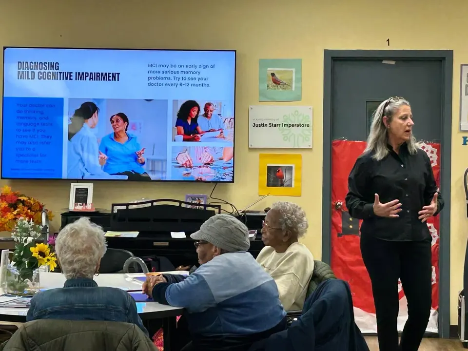 Grupo de personas mayores sonriendo tras un seminario de educación sobre demencia en Nueva Jersey