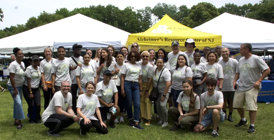 Un grupo de voluntarios de Act Now Foundation sonriendo juntos en la Feria de Salud Cerebral y Recursos Comunitarios, mostrando su compromiso con la sensibilización sobre la demencia en Nueva Jersey.