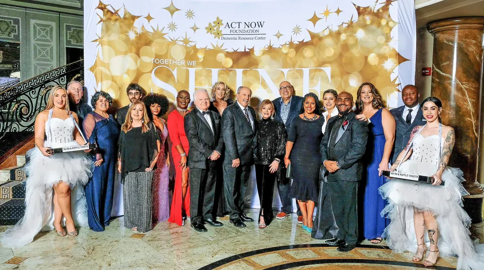 Grupo de asistentes a la gala posando frente al backdrop de Act Now Foundation