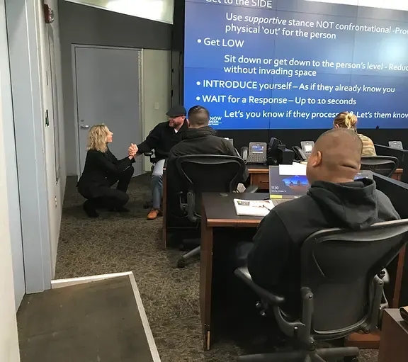 Personal de emergencias participando en ejercicios prácticos de concienciación sobre demencia durante una formación de Act Now Foundation