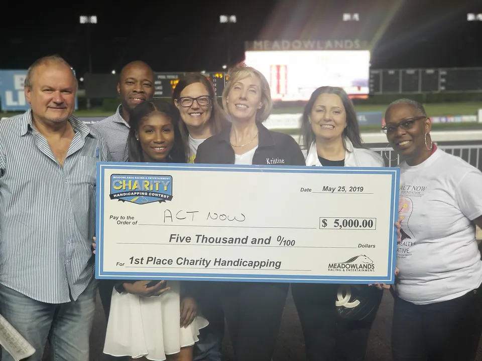 Equipo de Act Now Foundation sosteniendo un cheque de donación en el Meadowlands Charity Handicapping Contest