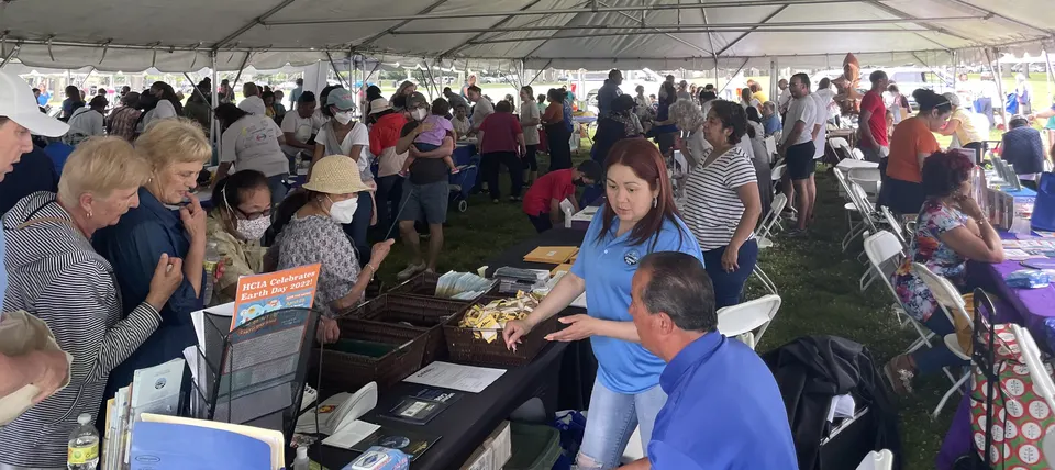 Residentes y familias conversando con proveedores locales en la Feria de Salud Cerebral y Recursos Comunitarios 2022 en Jersey City, informándose sobre recursos de demencia y envejecimiento saludable.
