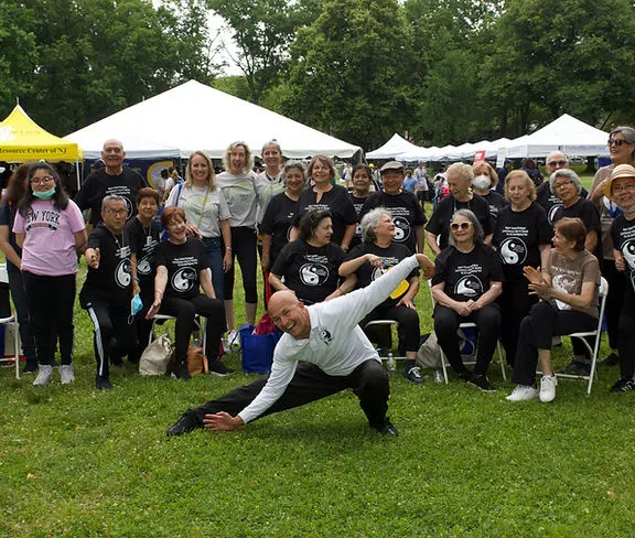 Un grupo de personas mayores participando en una clase de Tai Chi durante la Feria de Salud Cerebral y Recursos Comunitarios.