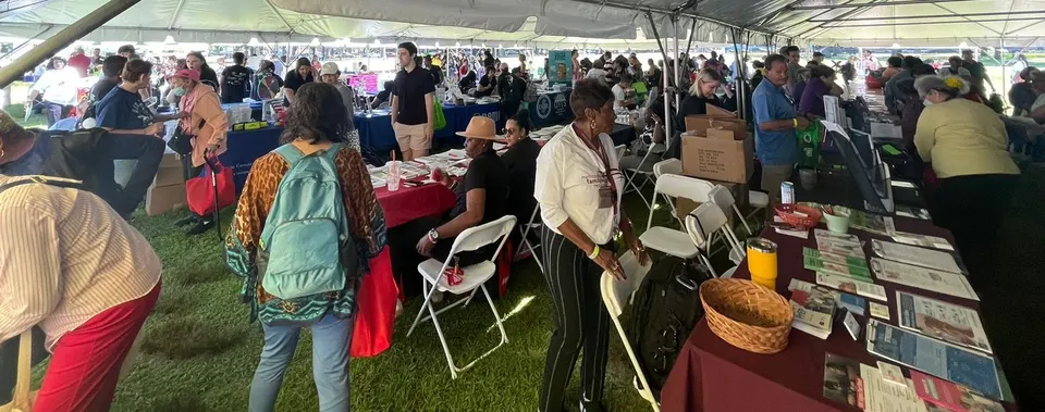 Asistentes a la Feria de Salud Cerebral y Recursos Comunitarios 2024 en un puesto que ofrece materiales educativos y recursos sobre salud cerebral.