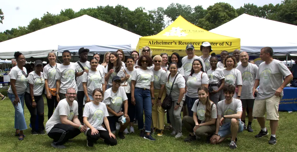 Miembros del equipo de Act Now Foundation sonriendo juntos en la Feria de Salud Cerebral y Recursos Comunitarios en Jersey City.