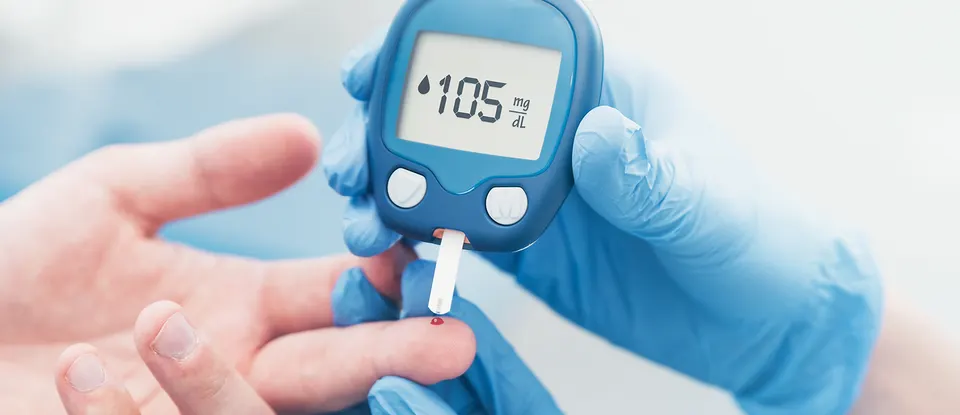 Primer plano de un dedo siendo pinchado para una prueba de glucosa, destacando el vínculo entre la diabetes y el riesgo de Alzheimer