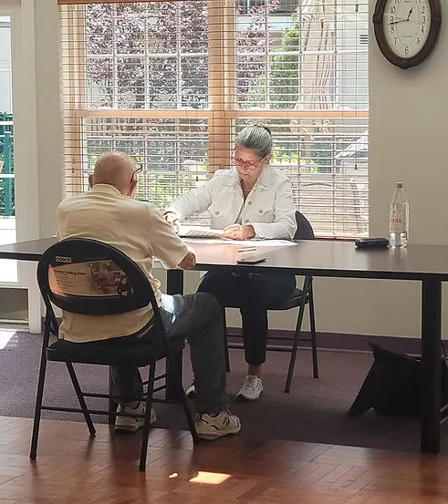 Cuidador recibiendo asesoría personalizada de cuidados a largo plazo durante una sesión de apoyo para la demencia