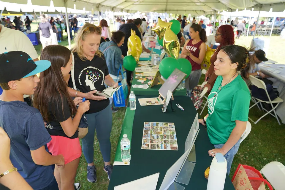Participantes en la Feria de Salud Cerebral y Recursos Comunitarios 2024 explorando actividades de bienestar y hablando con proveedores sobre la concienciación de la demencia y la atención preventiva.