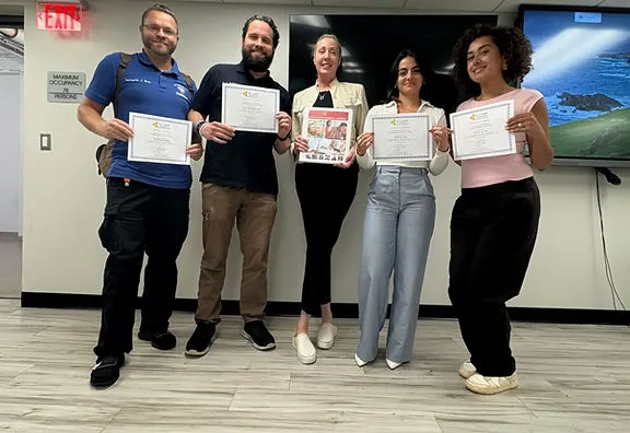 Participantes de la formación en demencia sosteniendo con orgullo sus certificados de finalización en Nueva Jersey