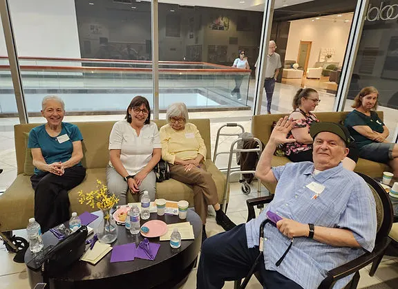 Grupo de personas mayores participando en un evento de Memory Café con entretenimiento en vivo