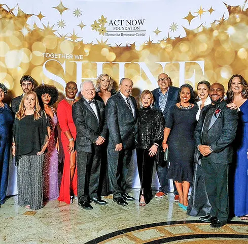 Asistentes posando frente al step and repeat en la Gala de Música y Recuerdos de Act Now Foundation