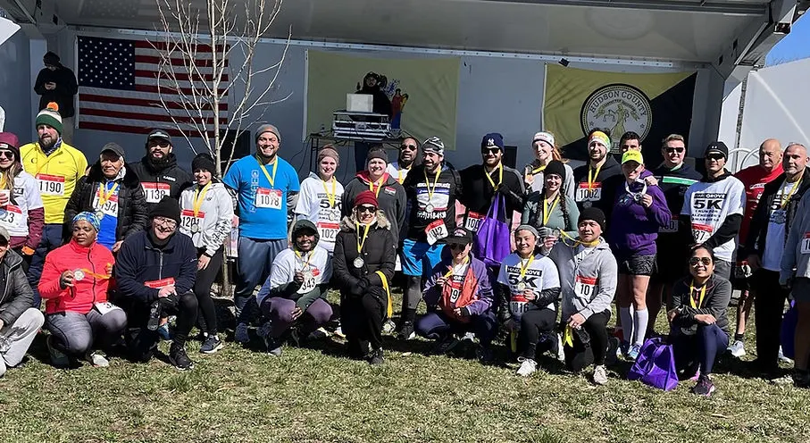 Miembros de la comunidad reunidos en un evento benéfico de 5K en Jersey City