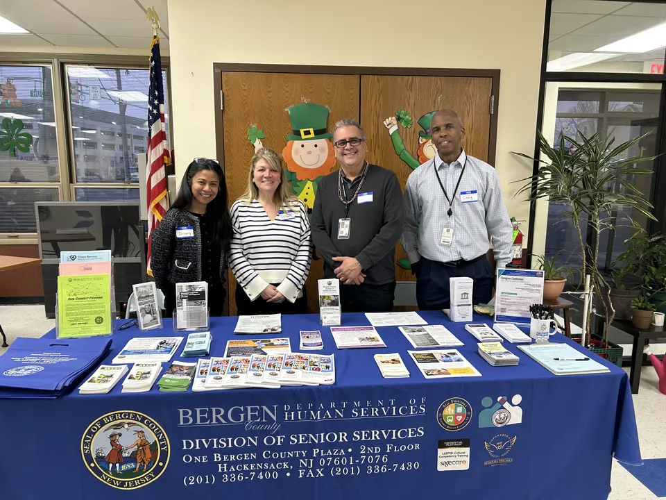 Personal de la Bergen County Division of Senior Services en una mesa ofreciendo recursos sobre demencia en un evento comunitario