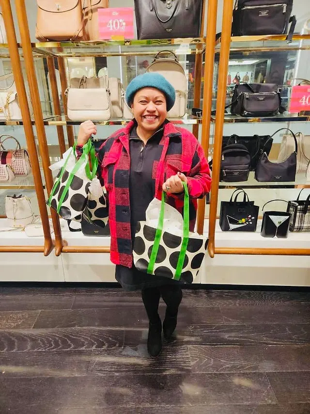 Asistente explorando artículos y disfrutando de la venta benéfica de Kate Spade en apoyo a Act Now Foundation